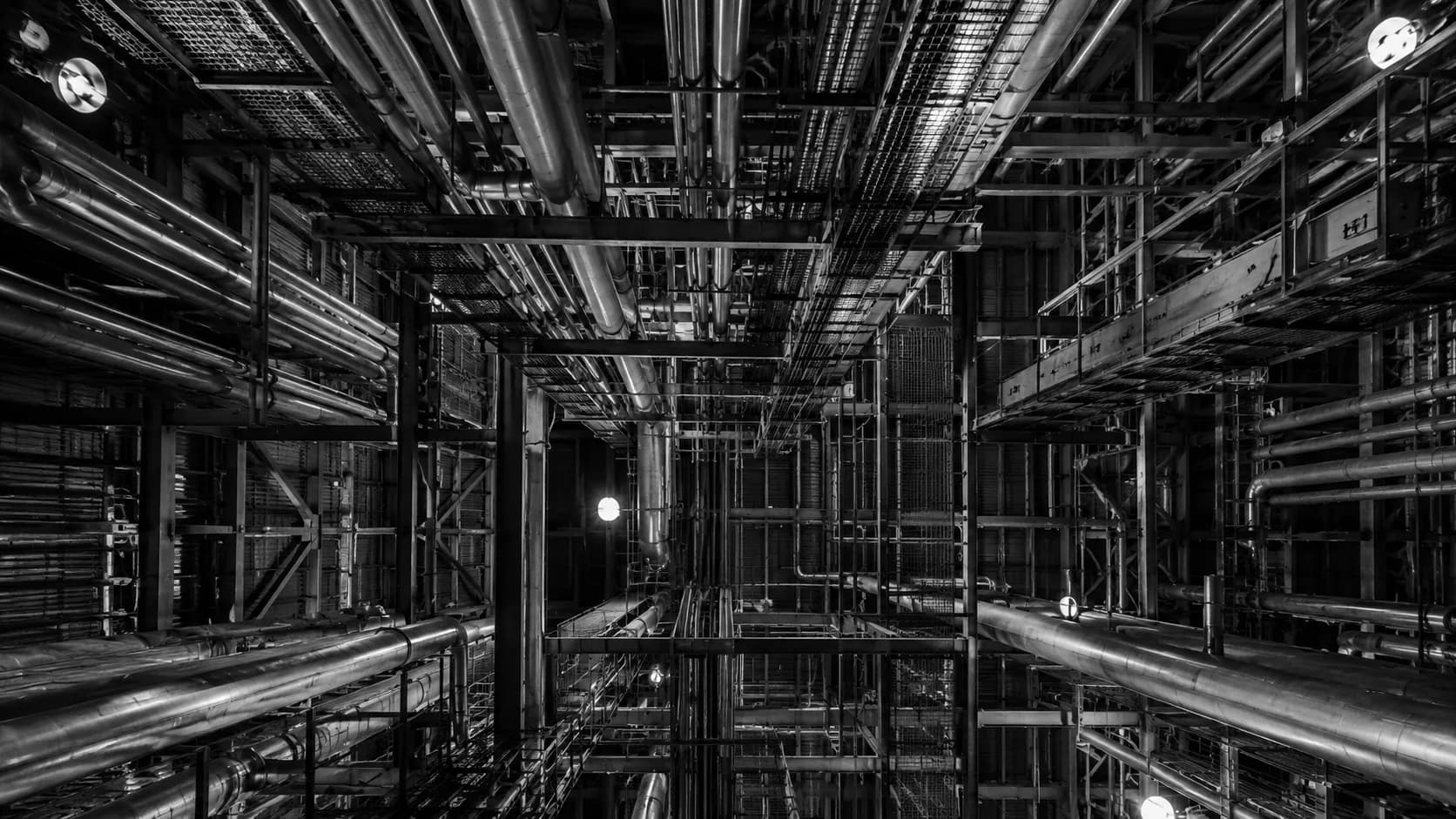 Industrial maze of pipes and beams in monochrome